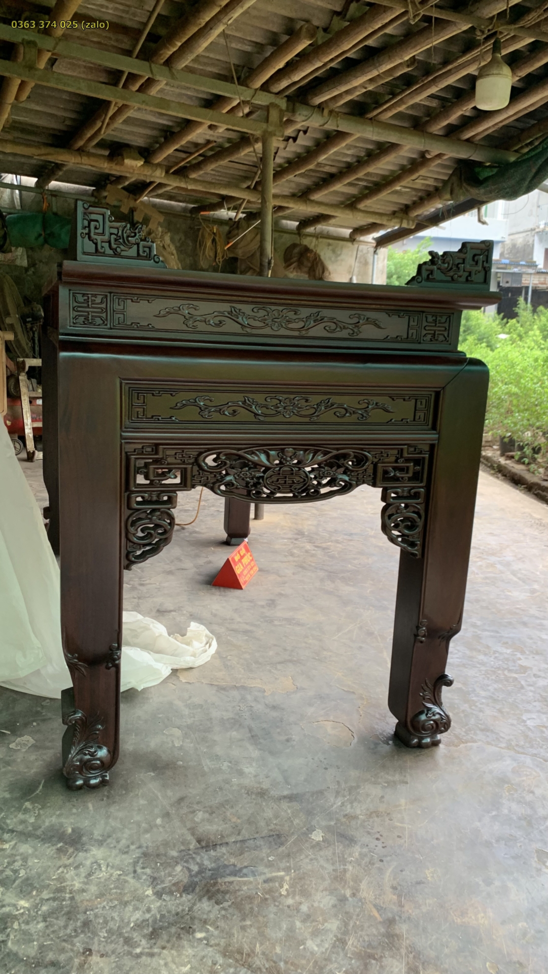Bên hông bàn thờ gỗ gụ với ô chạm khắc, dạ thoáng và chân bên